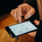 Close-up of a hand using a smartphone displaying a map for navigation.